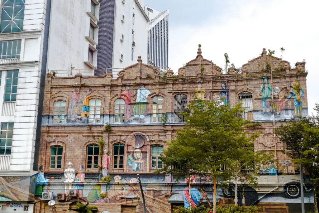 A heritage building in Kuala Lumpur adorned with a colourful mural depicting local scenes, part of the River of Life project