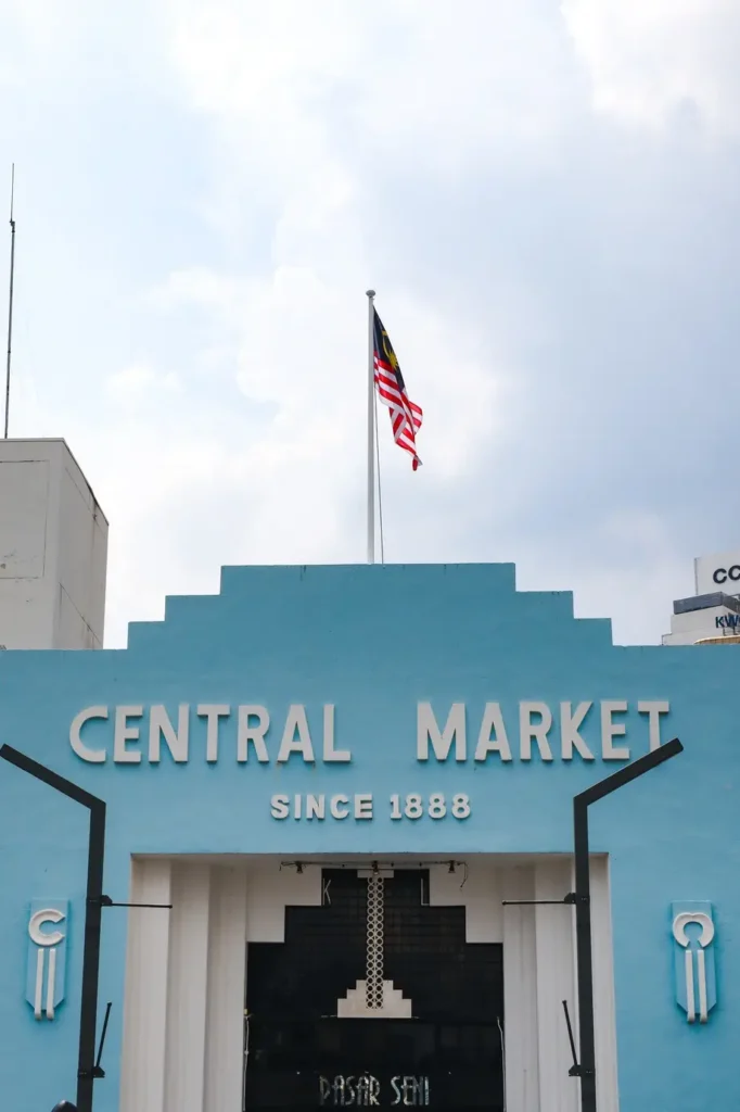 The entrance of Central Market in Kuala Lumpur, a heritage site and popular spot for traditional arts and crafts, with a Malaysian flag above.