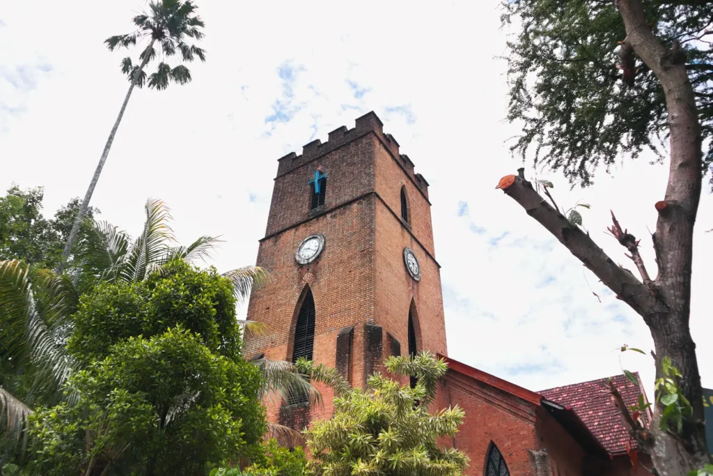 The red-brick St. Paul’s Church in Kandy, featuring a clock tower and surrounded by lush green foliage. Visiting this historic church is one of the enriching cultural experiences among Kandy attractions.