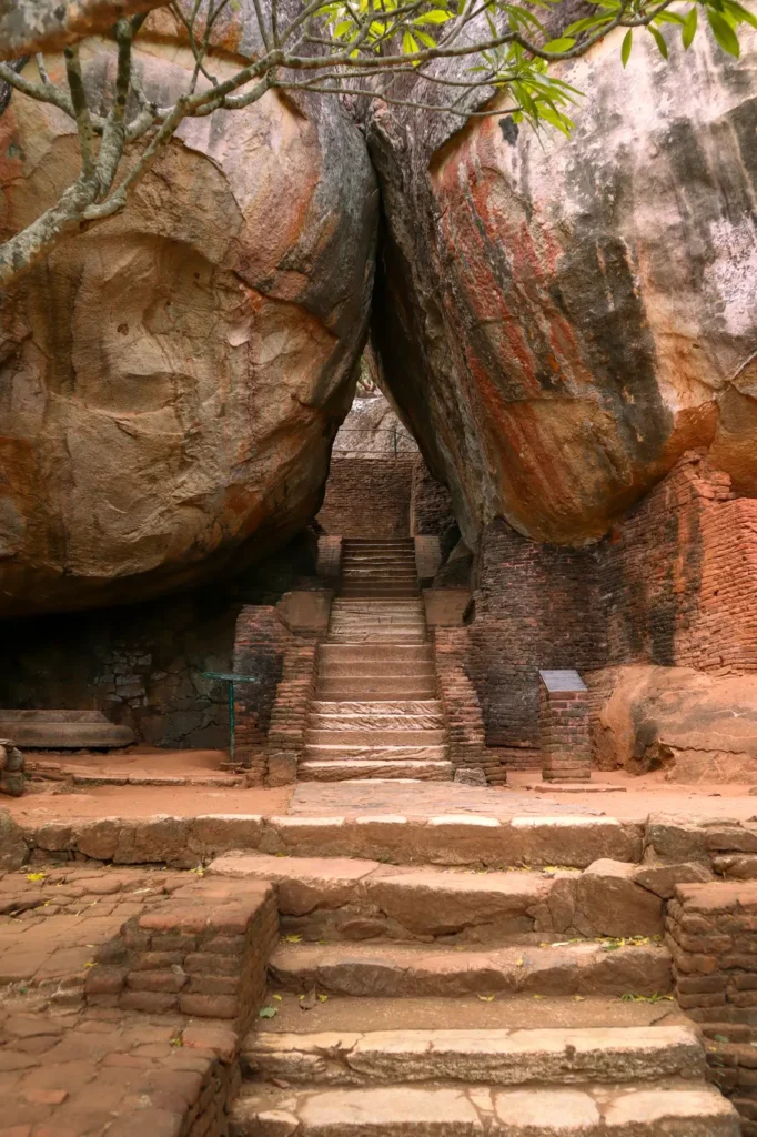 A grand stone staircase leading through a narrow passage between two massive boulders at Sigiriya