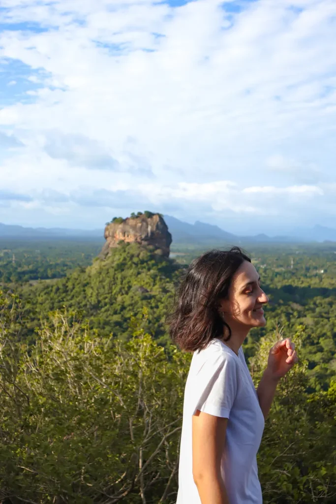 Me smiling joyfully in the foreground with the majestic Lion Rock rising above lush greenery in the distance