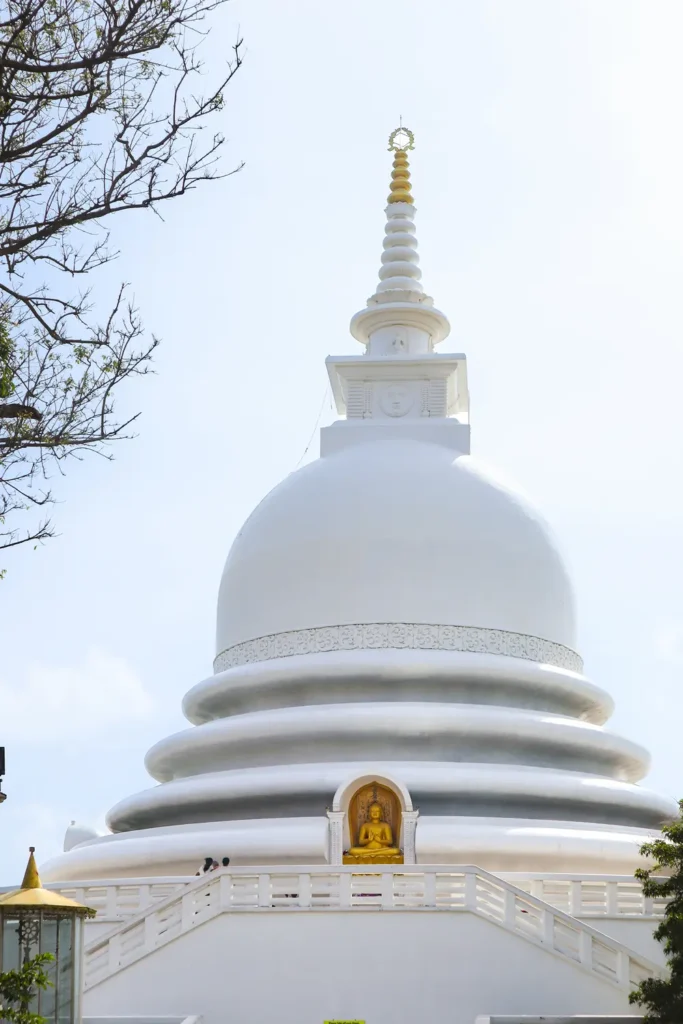The iconic Peace Pagoda in Mirissa, a gleaming white Buddhist stupa with a golden Buddha statue and panoramic ocean views—one of the most peaceful and spiritual places to visit in Mirissa.