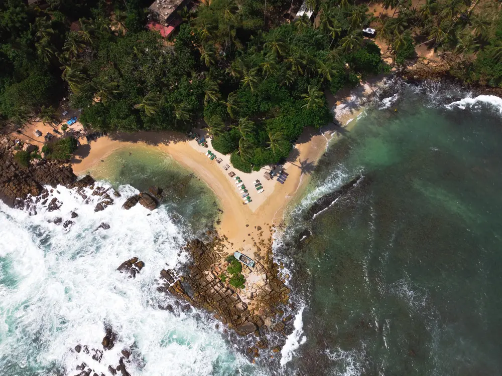 Sweeping ocean view of the secret cove near Mirissa with loungers on a secluded beach—highlighting one of the top peaceful places to visit in Mirissa.