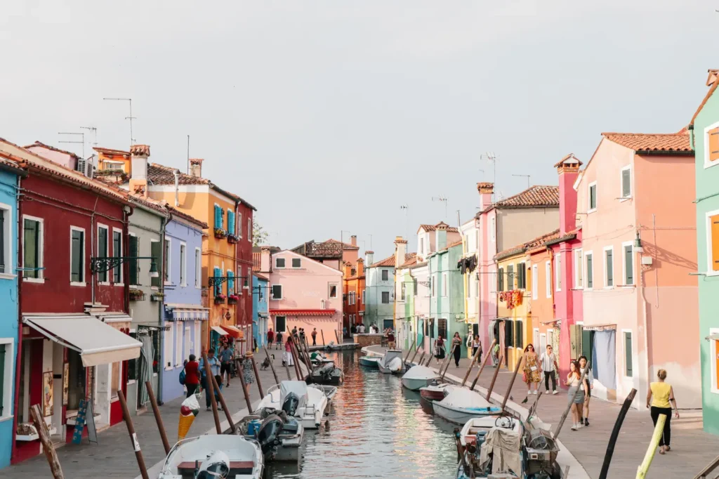 21 locais a visitar no norte de Itália que vos vão conquistar facilmente 23 Bright pastel buildings line a quiet canal in Burano as boats float along the water, offering a unique and colorful spot among the best places to visit in Northern Italy.