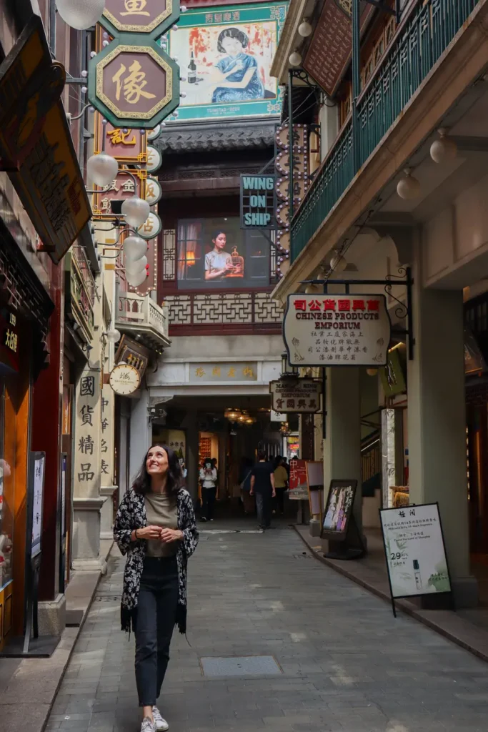 2 weeks in China: the perfect first-timer itinerary for an unforgettable trip 13 Mariana strolls down a narrow lane filled with colorful vertical Chinese signs and nostalgic posters in Shanghai’s Old Town.