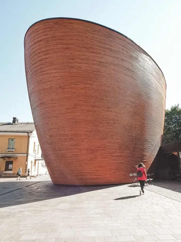Where to stay in Helsinki: the best neighborhoods & hotels 3 Modern wooden Kamppi Chapel of Silence with its curved design in central Helsinki, located near top hotels and accommodations.