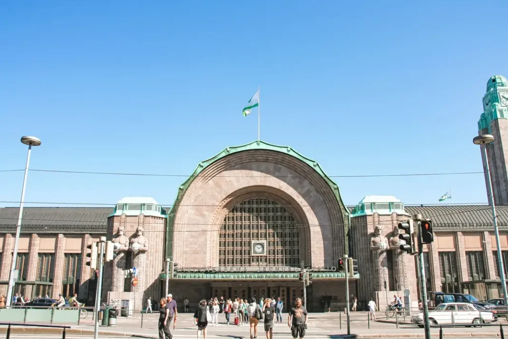Where to stay in Helsinki: the best neighborhoods & hotels 2 Front view of Helsinki Central Station with its arched entrance, stone statues, and busy crowd. Key reference point for where to stay in Helsinki.